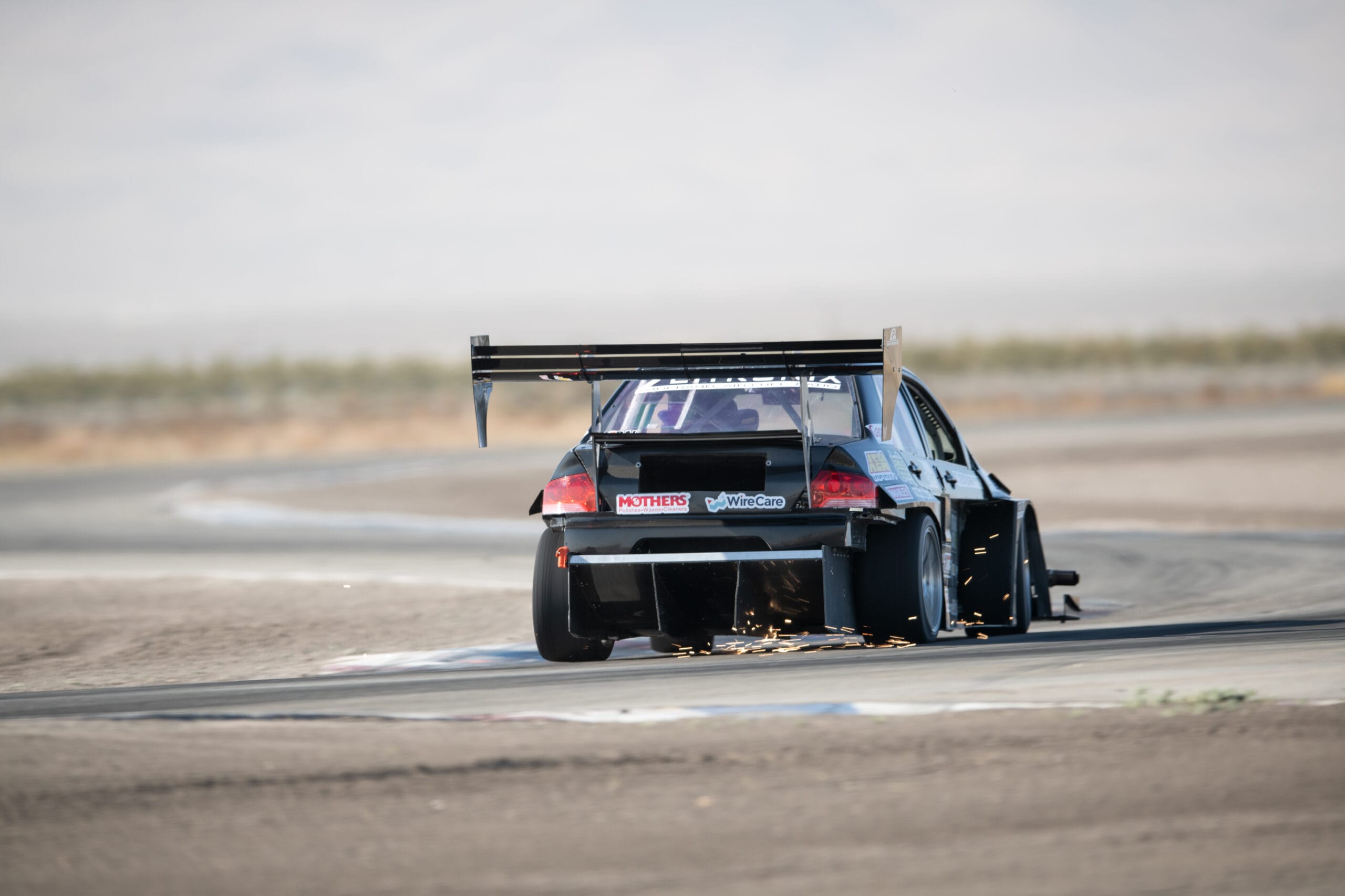 Professional Awesome titanium skid blocks producing sparks during on-track use