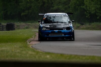 Front track view of a 1999 Dodge Neon with a full-width splitter and support rods