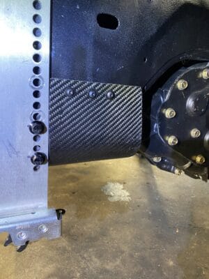 Close-up of a Professional Awesome quick-release splitter mount attached beside the core support on a 1999 Dodge Neon