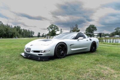 Three-quarter view of Justin Crews’ silver 2000 Chevrolet Corvette C5 with its homemade carbon front splitter installed