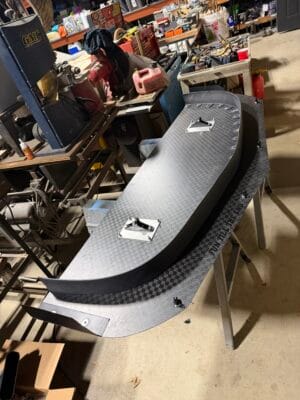 Top view of a homemade carbon Corvette C5 splitter with rectangular openings for the quick-release mounts