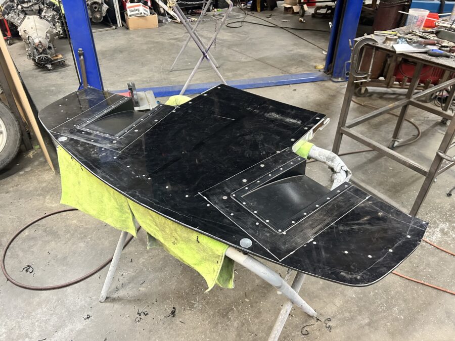Underside of Drew’s ABS splitter on a work stand showing two inset splitter diffusers and rows of flush fasteners.