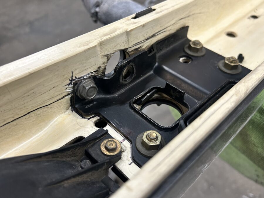 Close-up of mounting hardware and clearance cutouts inside Drew’s BMW E30 bumper support assembly.