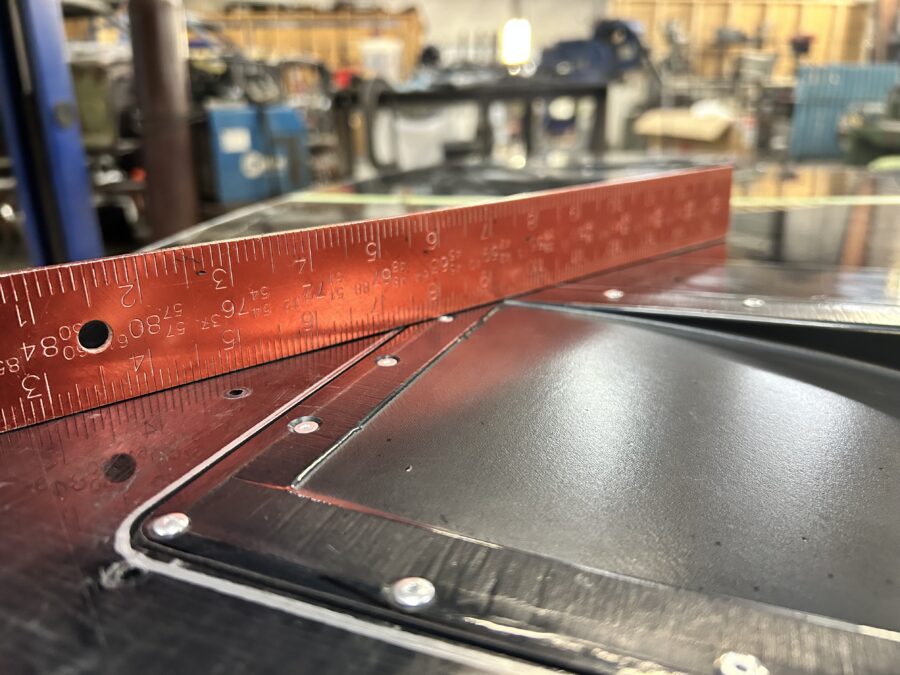 Close-up of a splitter diffuser inset and flush rivets beside a ruler on Drew’s BMW E30 ABS splitter.