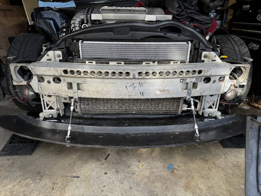 Bumper-off front view of the R53 MINI showing quick-release splitter mounts and support rods attached below the crash bar
