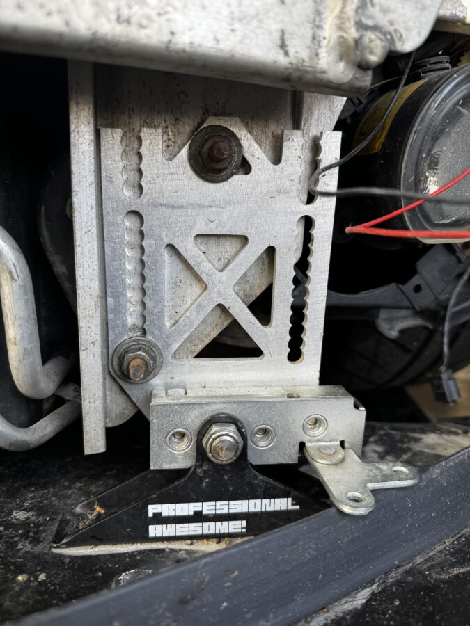 Close-up of the opposite quick-release mounting plate and splitter bracket beneath the R53 MINI’s crash bar