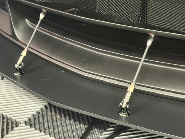 Close-up of the two splitter support rods and mounting hardware across the Boss 302 lower bumper opening.