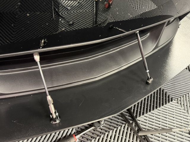 Angled view of the Boss 302 splitter support rod pair showing the lower clevis mounts and upper attachment areas.